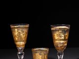 three glasses of champagne on a table with a black background