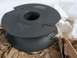 a black spool sitting on a brown piece of paper