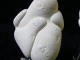 two white sculptures of a man and a woman on a black background