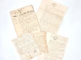 several old letters are sitting on top of each other on a white surface