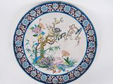une assiette bleue et blanche ornée d'un motif représentant des oiseaux et des fleurs