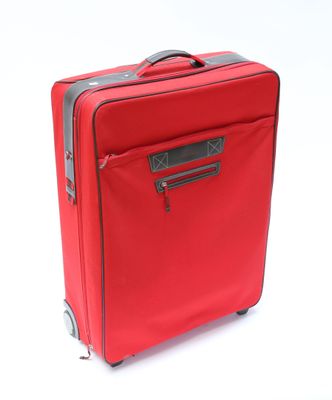 une valise rouge posée sur une surface blanche