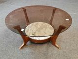 une table en verre avec un plateau en marbre et des pieds en bois