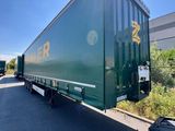a green semi truck that is parked on the side of the road
