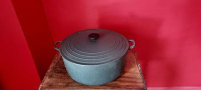 un pot posé sur une table en bois devant un mur rouge