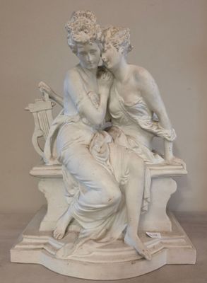 une statue représentant une femme et un homme assis sur un banc