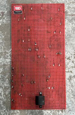 un gros plan d'un morceau de métal rouge posé sur une surface en béton
