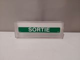 a green and white sign sitting on top of a white counter