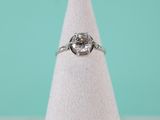 a close up of a diamond ring sitting on top of a white cone