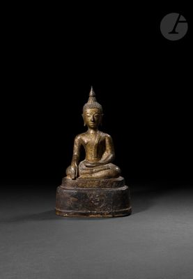 a bronze figure of a seated buddha on a pedestal