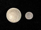 an image of a silver coin and a silver coin on a black surface