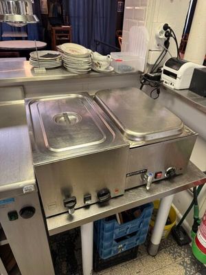 une cuisine avec de nombreux éléments en inox sur le plan de travail
