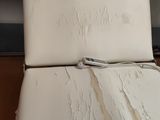 une chaise blanche dont la peinture s'écaille, dans une pièce
