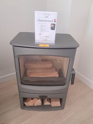 un petit poêle à bois surmonté d'une pancarte