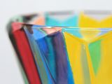 a glass vase with a lot of colored glass inside of it
