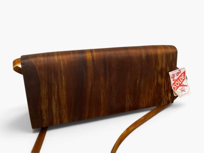 porte-monnaie en cuir marron avec lanière et étiquette sur fond blanc