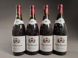 four bottles of wine are lined up on a table