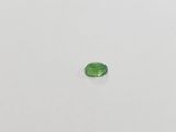 a green tourmaline gems on a white surface