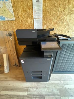 une imprimante noire posée sur une pile de cartons