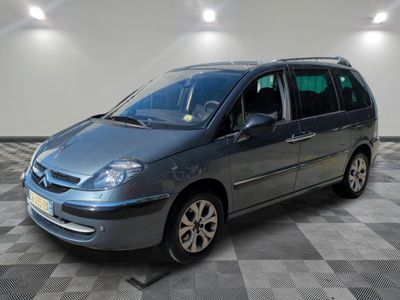 une photo d'un monospace gris garé dans un garage