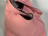 pink leather handbag on white background with black handles