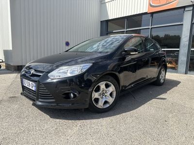 une voiture noire garée devant un bâtiment dans un parking