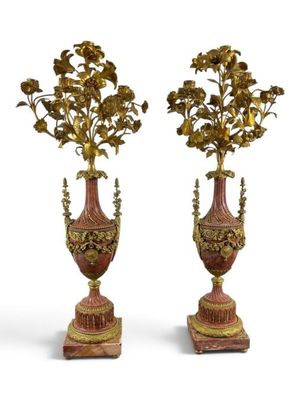 two vases with flowers on top of each other on a white surface
