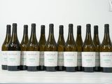 six bouteilles de vin sont alignées sur une table