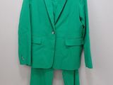 a green suit hanging on a wall next to a hanger