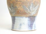 a vase that is sitting on a white surface