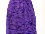 a purple and green dress on a hanger on a white wall