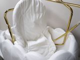 a white chair that has a gold frame around it