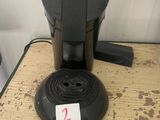 une cafetière posée sur une table, avec une étiquette de prix dessus
