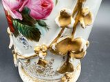 a vase with flowers painted on it sitting on a table