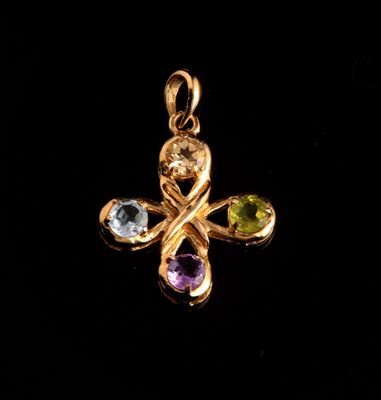 un pendentif en forme de croix en or, orné de pierres multicolores sur fond noir