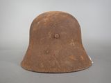 an old helmet is sitting on a table on a gray surface