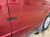 a close up of a red car door with a sticker on it