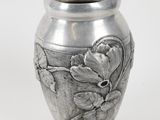 un vase en argent orné de fleurs sur fond blanc