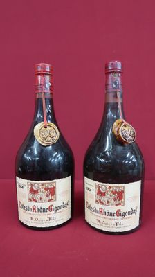 two bottles of wine sitting next to each other on a red surface