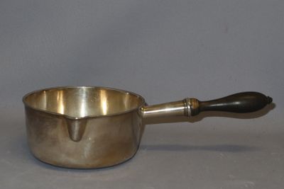 a silver saucepan with a wooden handle on a table