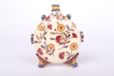 a white vase with a floral design on it