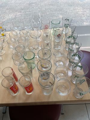bottles and glasses on a table with a window in the background