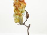 a close up of a statue of an owl on a branch