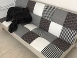 un canapé à carreaux noirs et blancs sur lequel est couché un chien noir