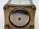 an antique brass clock on a white surface with a white background