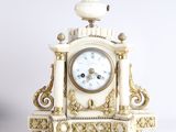 une horloge blanche et or posée sur une table