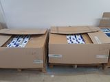 de nombreux cartons posés sur des palettes dans la pièce