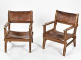 two brown leather chairs sitting next to each other on a white surface
