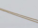 a close up of a gold chain on a white surface