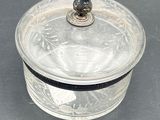 a glass box with a silver lid on a table